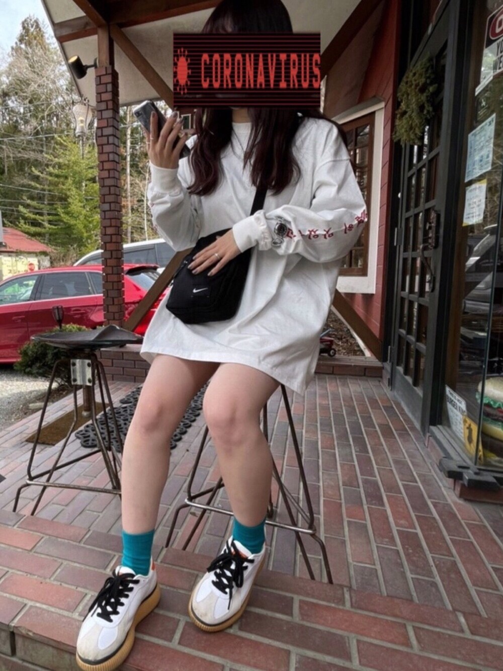 ホワイト系のTシャツ/カットソー、ブラック系のショルダーバッグ、ホワイト系のスニーカーを着用したレディースの春コーディネートの1枚目の写真