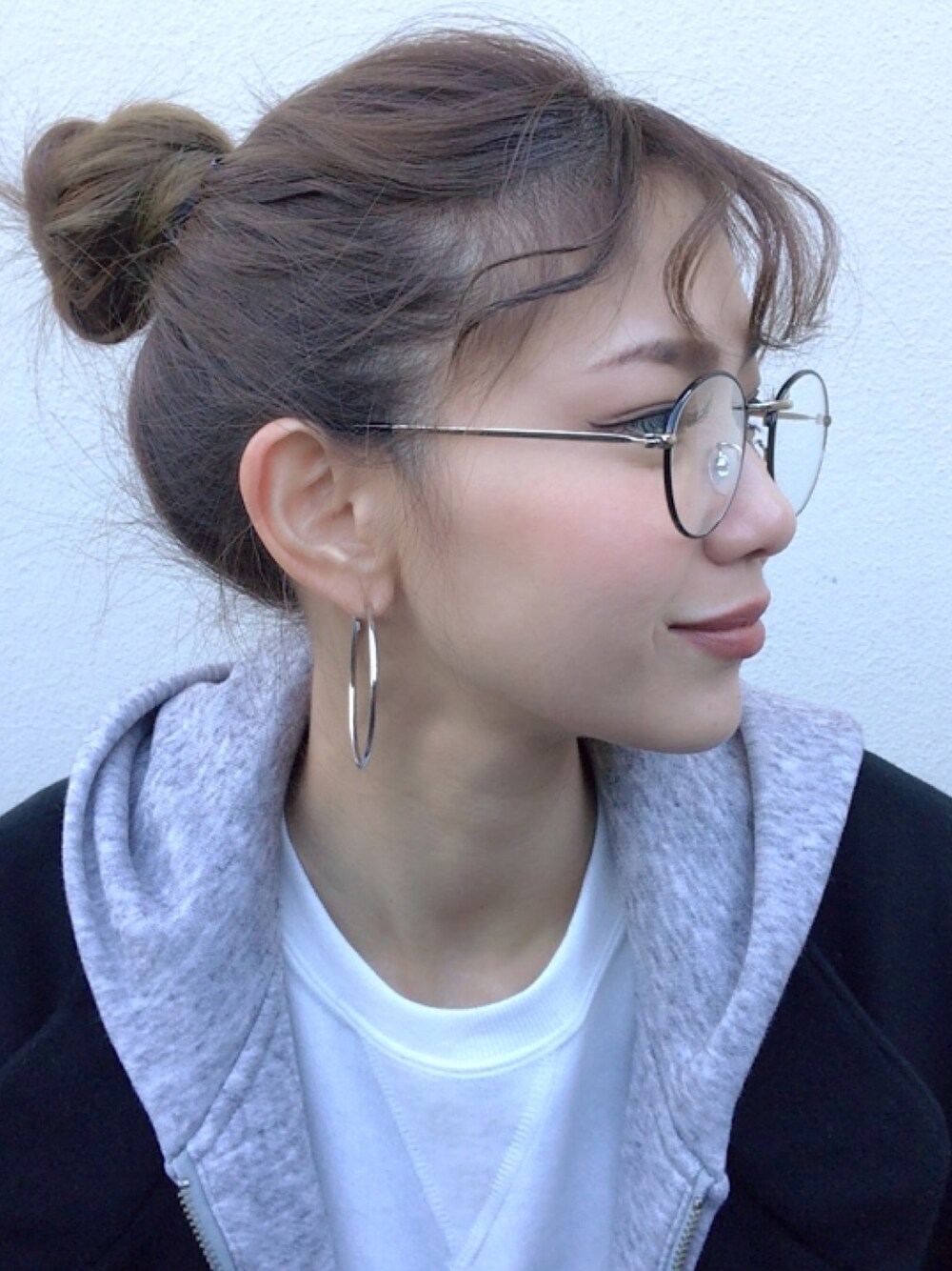 ブラック系のメガネを着用したレディースの冬コーディネートの1枚目の写真