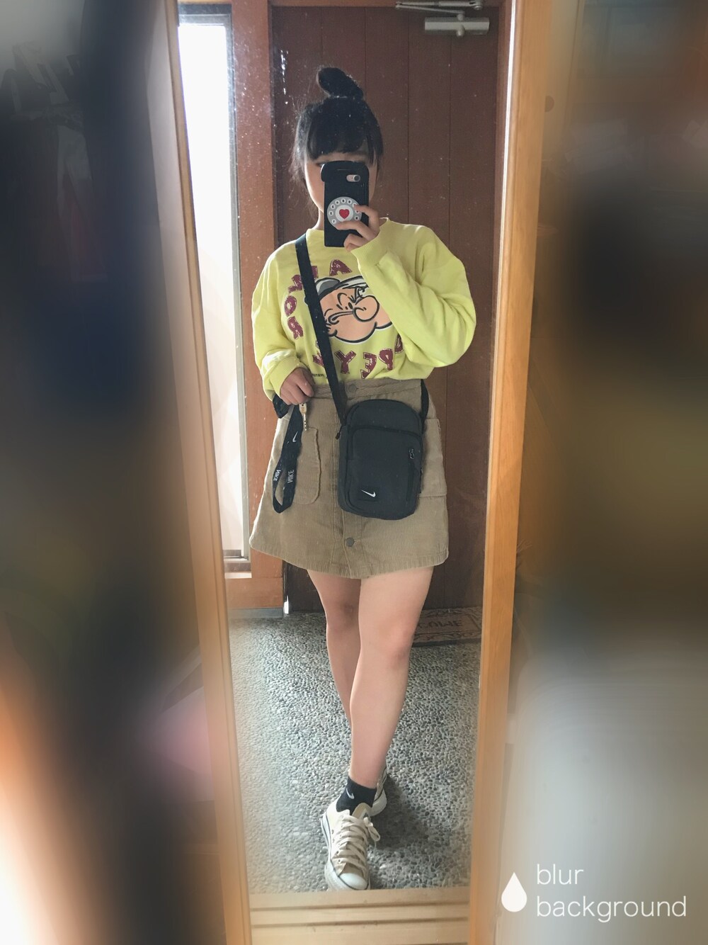 グレー系のショルダーバッグ、イエロー系のスウェット、ベージュ系のスカートを着用したレディースの秋コーディネートの1枚目の写真