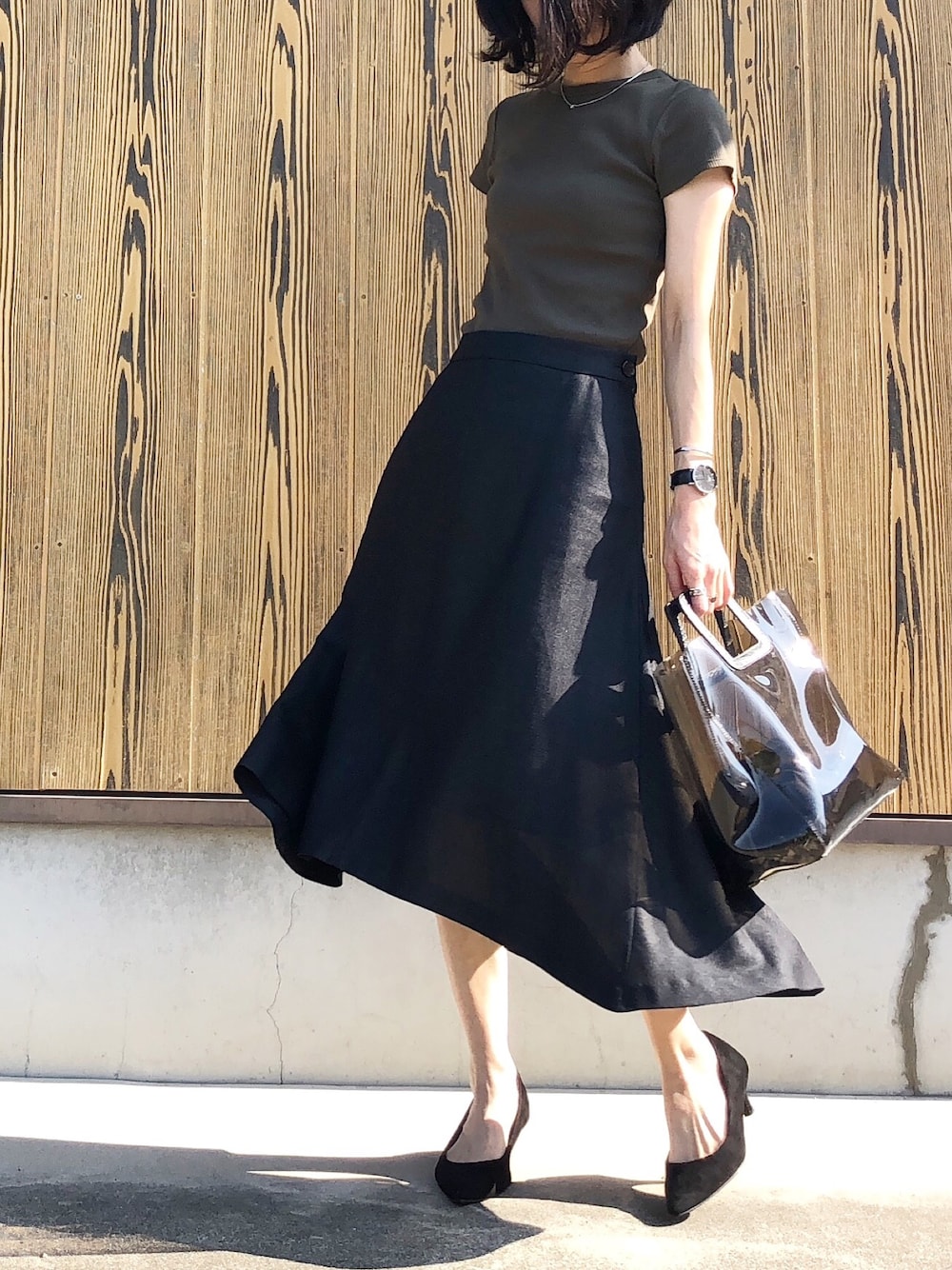 グリーン系のTシャツ/カットソー、ブラック系のスカート、ブラック系のパンプスを着用したレディースの夏コーディネートの1枚目の写真