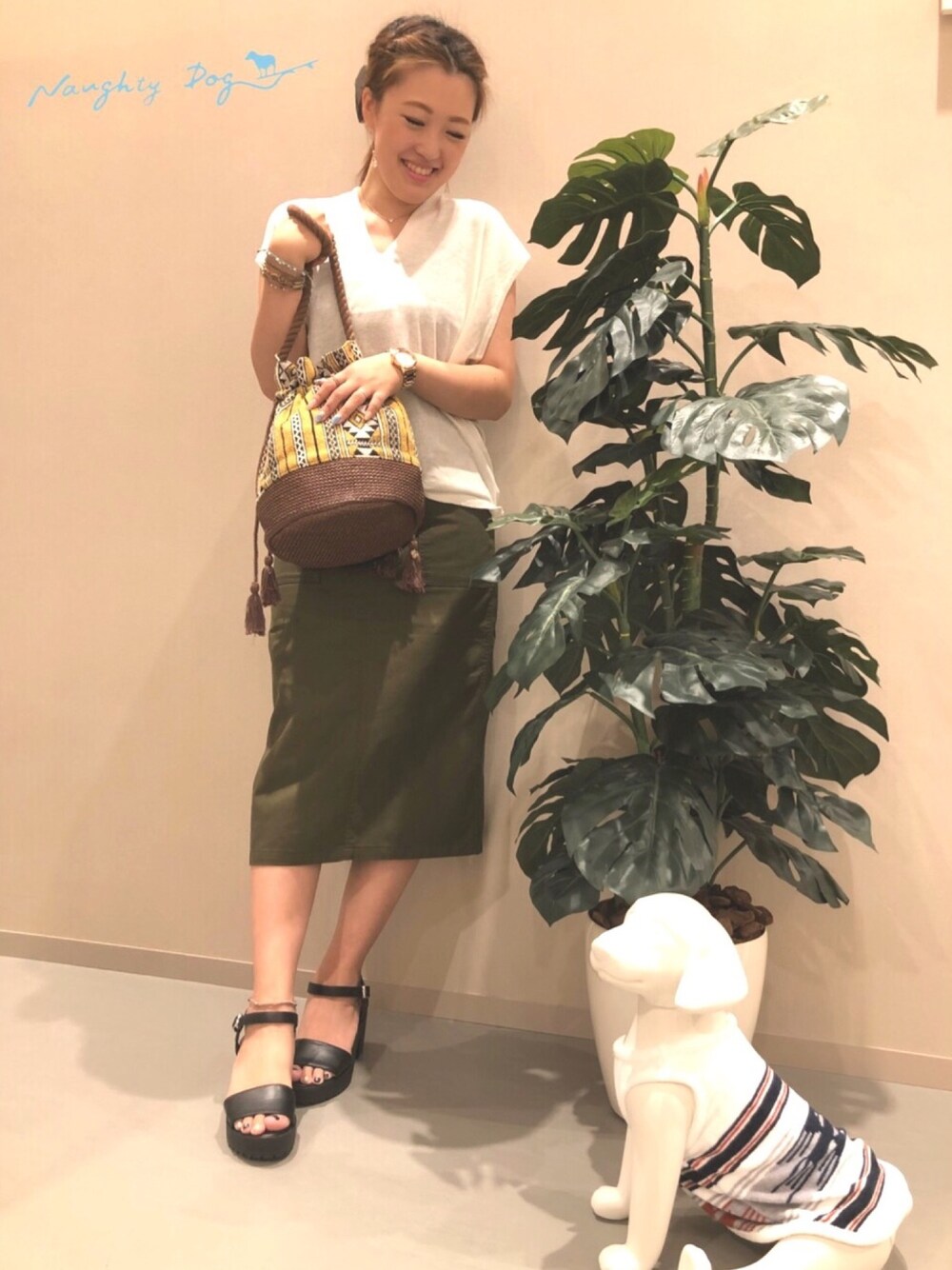 ホワイト系のニット/セーター、グリーン系のスカート、イエロー系のトートバッグを着用したレディースの夏コーディネートの1枚目の写真