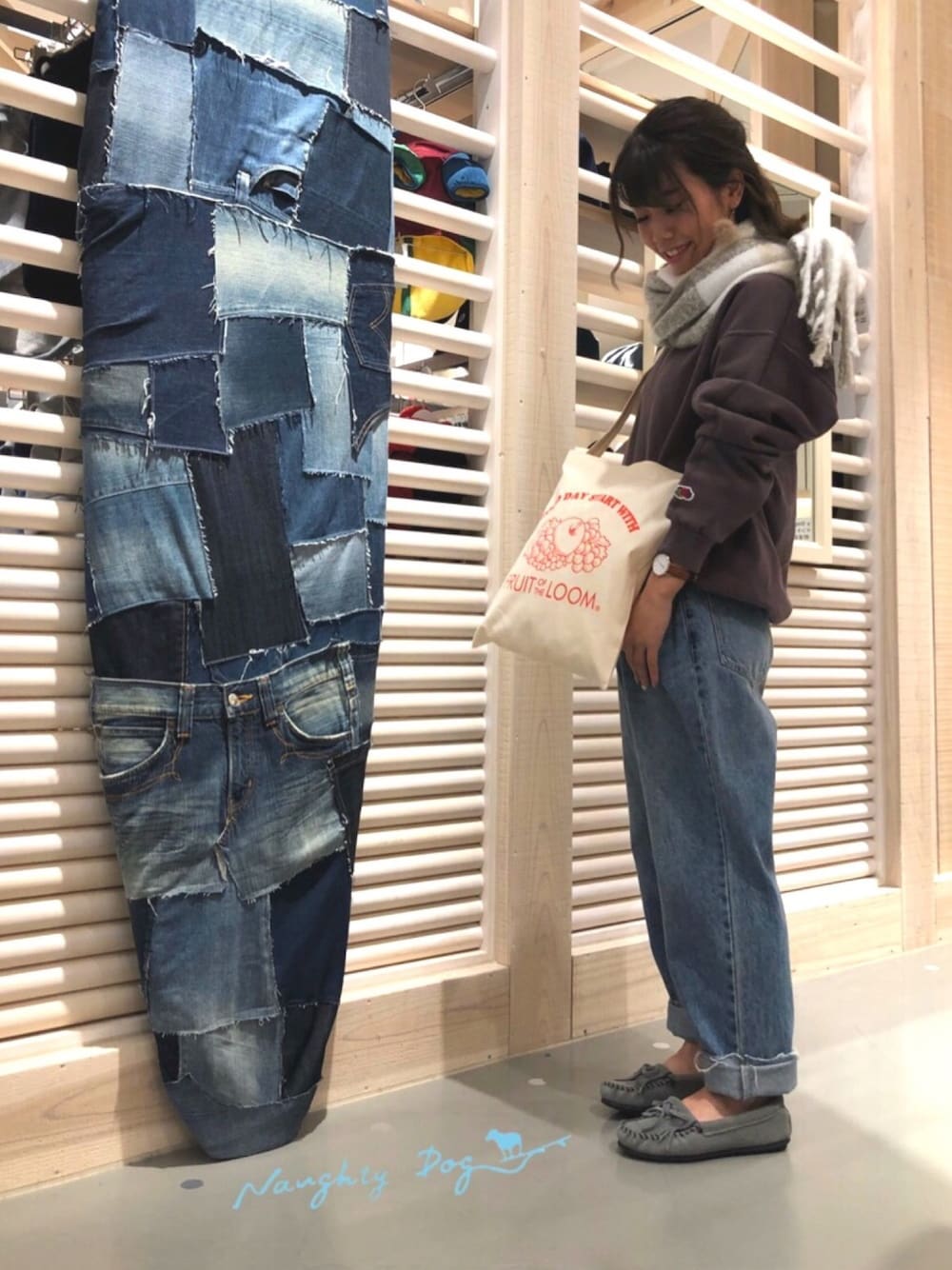 パープル系のスウェット、ブルー系のデニムパンツ、グレー系のモカシン/デッキシューズを着用したレディースの秋コーディネートの1枚目の写真