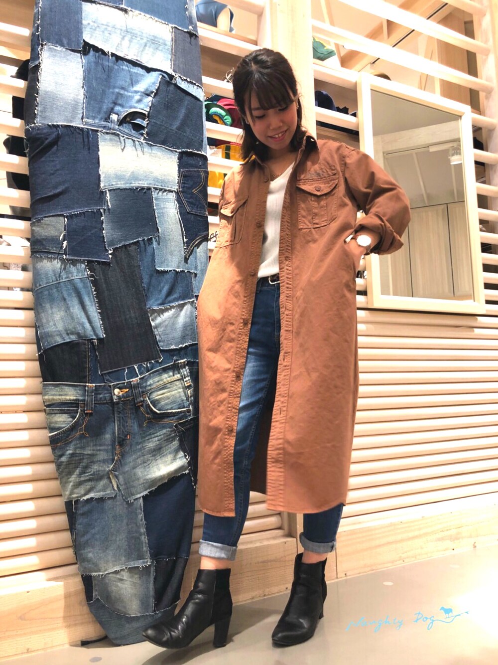 ブラウン系のシャツワンピース、ブルー系のデニムパンツを着用したレディースの冬コーディネートの1枚目の写真