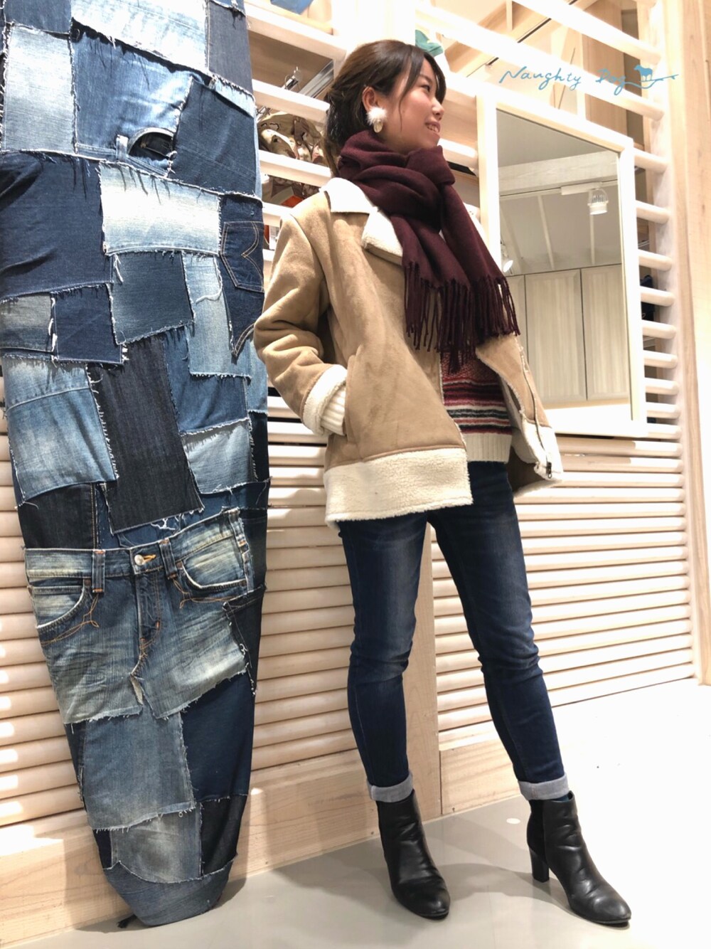 ベージュ系のその他アウター、レッド系のニット/セーター、ブルー系のデニムパンツを着用したレディースの冬コーディネートの1枚目の写真
