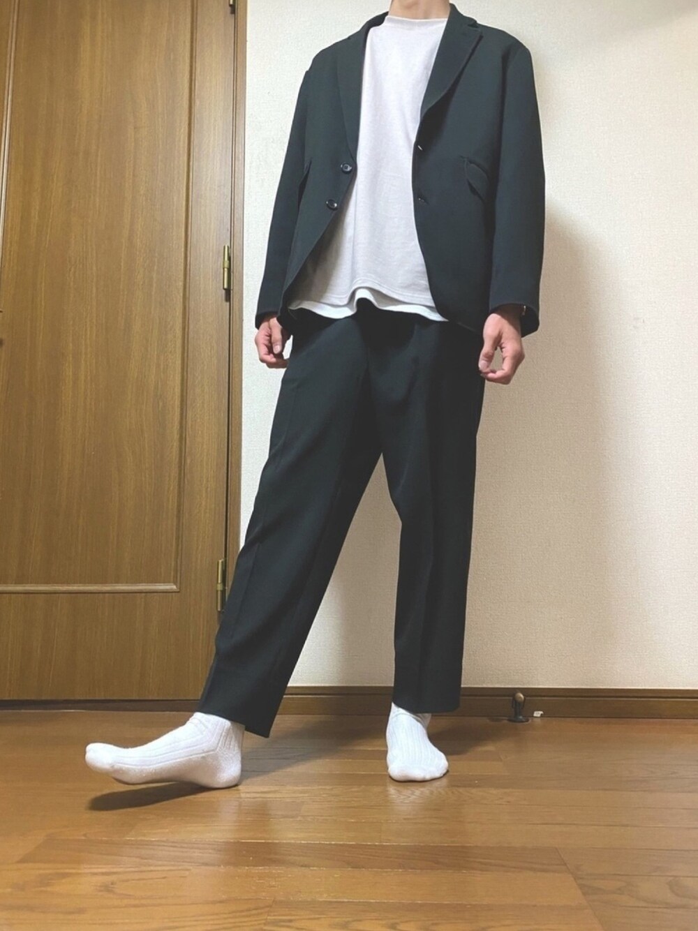 ブラック系のセットアップ、ベージュ系のTシャツ/カットソー、ホワイト系のタンクトップを着用したメンズの春コーディネートの1枚目の写真