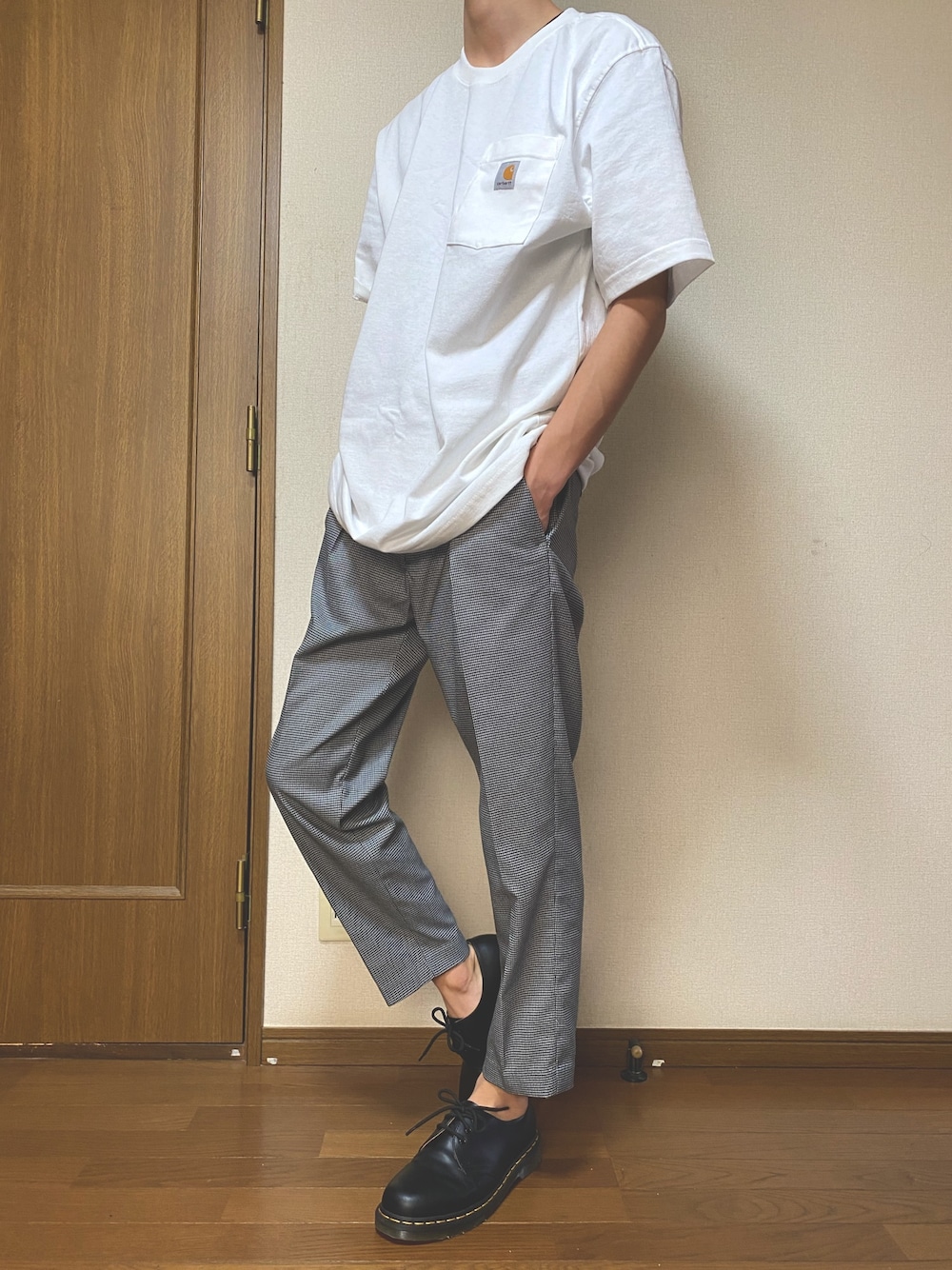 ホワイト系のTシャツ/カットソー、グレー系のスラックス、ブラック系のドレスシューズを着用したメンズの春コーディネートの1枚目の写真