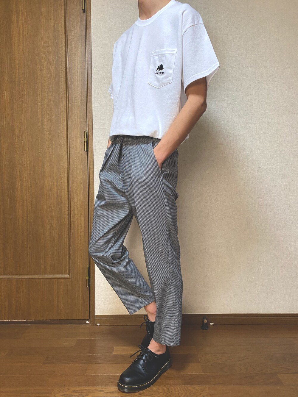 ホワイト系のTシャツ/カットソー、グレー系のスラックス、ブラック系のドレスシューズを着用したメンズの春コーディネートの1枚目の写真