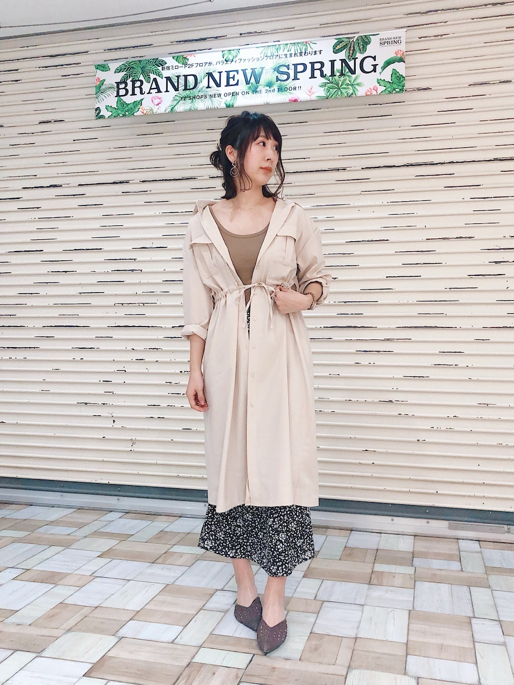 ホワイト系のシャツワンピース、ブラック系のスカートを着用したレディースの春コーディネートの1枚目の写真