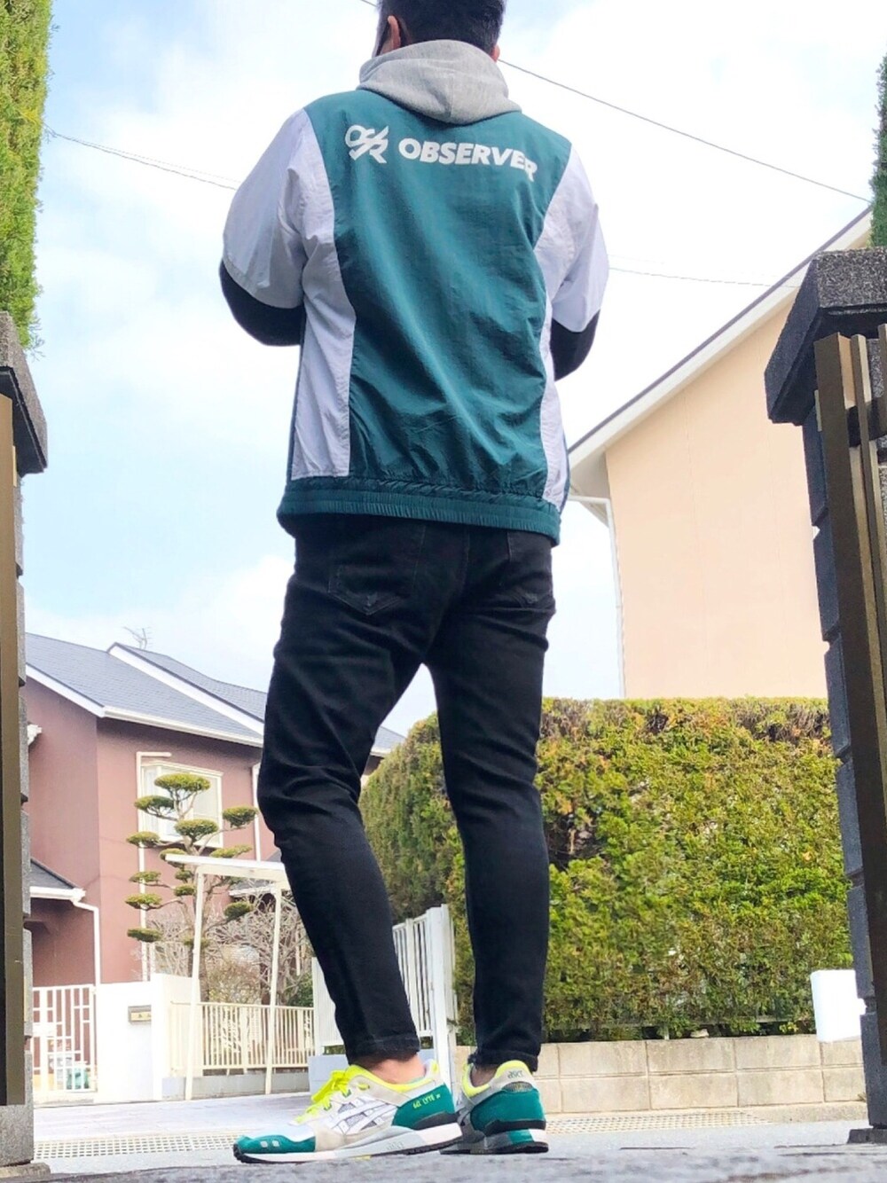 グレー系のパーカー、グリーン系のブルゾン、ブラック系のデニムパンツを着用したメンズの冬コーディネートの1枚目の写真