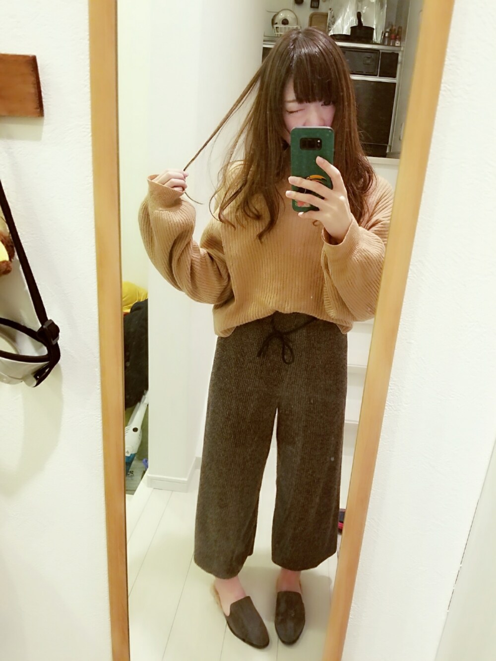 グレー系のサンダル、イエロー系のニット/セーターを着用したレディースの冬コーディネートの1枚目の写真