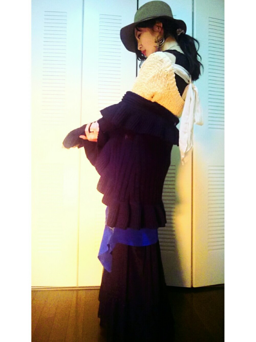 ベージュ系のニット/セーター、ブルー系のシャツ/ブラウス、ブラック系のスカートを着用したレディースの冬コーディネートの1枚目の写真