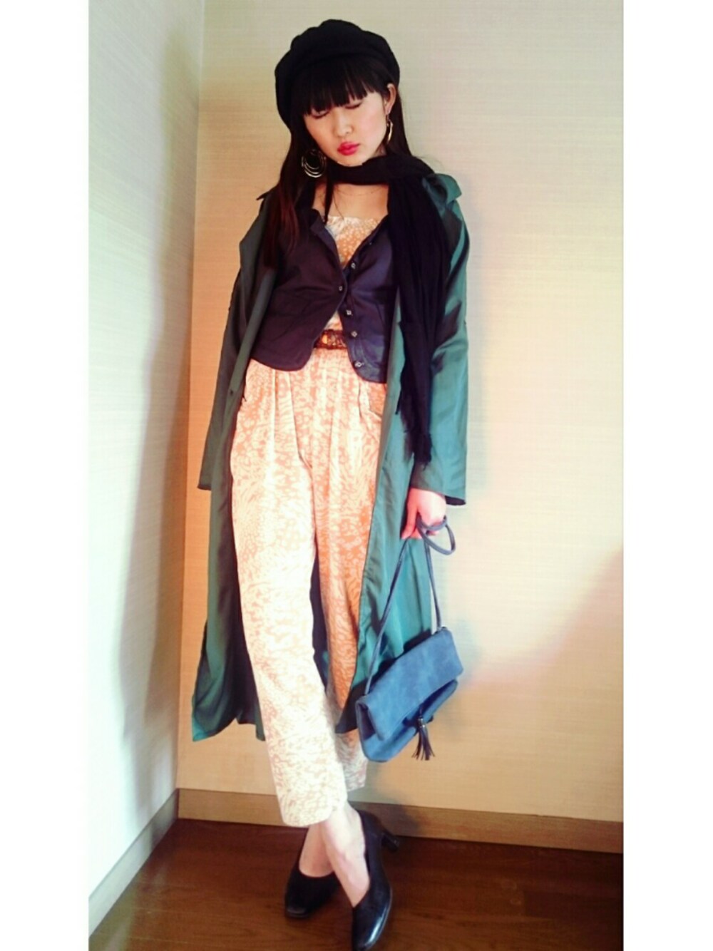 オレンジ系のつなぎ/オールインワン、ブラック系のカーディガン/ボレロ、ブラック系のシューズを着用したレディースの春コーディネートの1枚目の写真