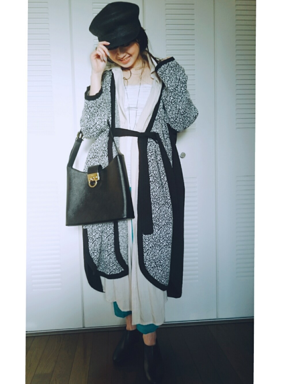 ブラック系のカーディガン/ボレロ、ホワイト系のチューブトップ、ブラック系のバッグを着用したレディースの春コーディネートの1枚目の写真