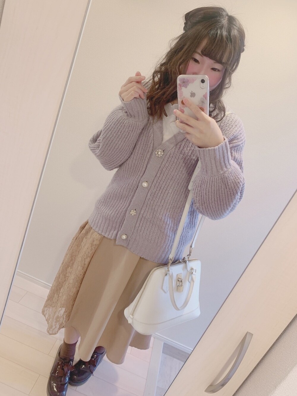 パープル系のカーディガン/ボレロ、ブラック系のTシャツ/カットソー、ベージュ系のスカートを着用したレディースの冬コーディネートの1枚目の写真