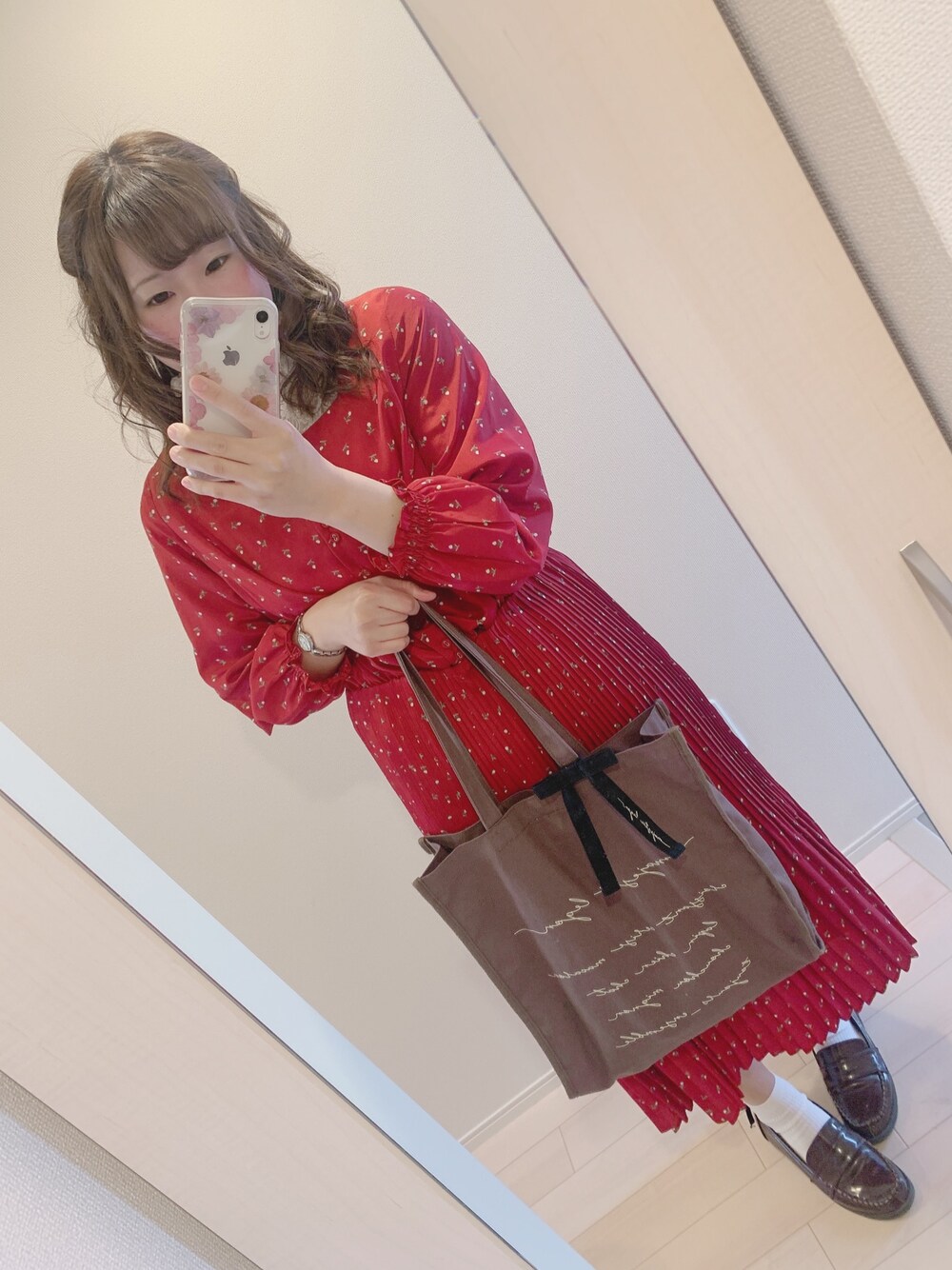 レッド系のワンピース、ブラウン系のトートバッグ、ブラウン系のローファーを着用したレディースの春コーディネートの1枚目の写真