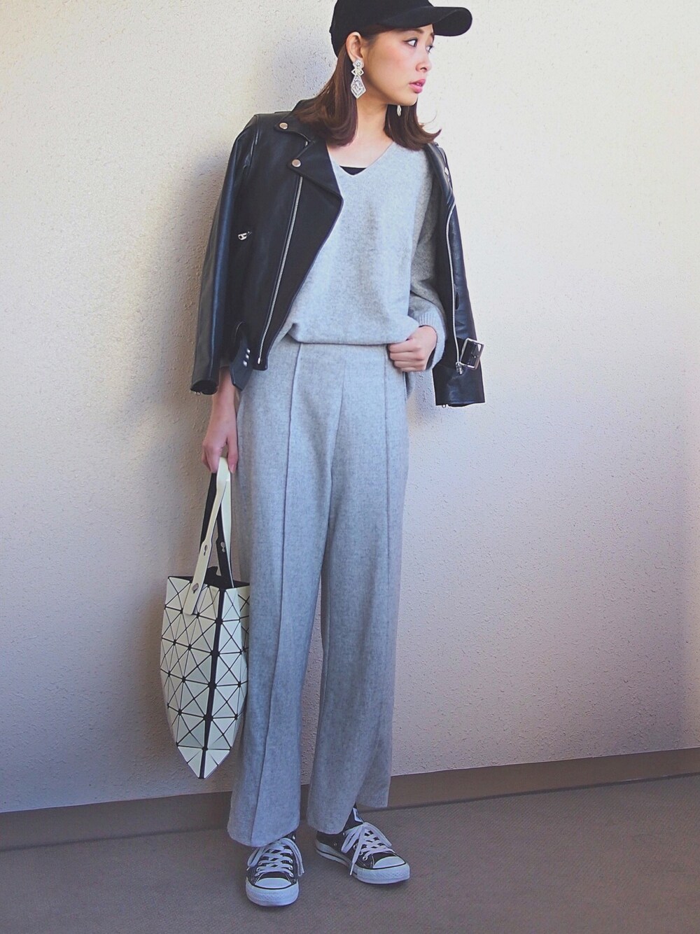 ブラック系のライダースジャケット、グレー系のニット/セーター、グレー系のその他パンツを着用したレディースの冬コーディネートの1枚目の写真