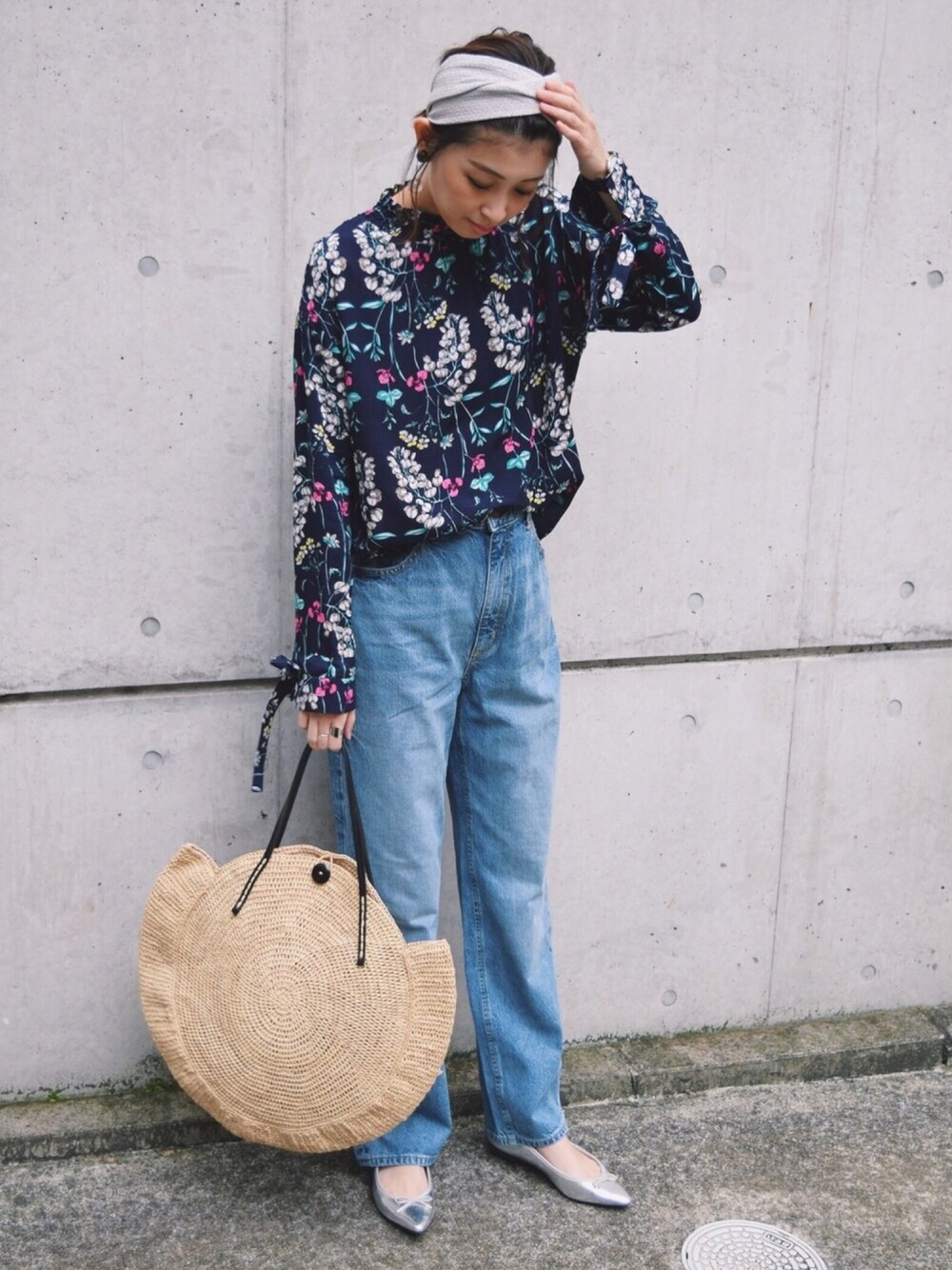 ブルー系のデニムパンツ、ベージュ系のかごバッグ、ブルー系のシャツ/ブラウスを着用したレディースの春コーディネートの1枚目の写真