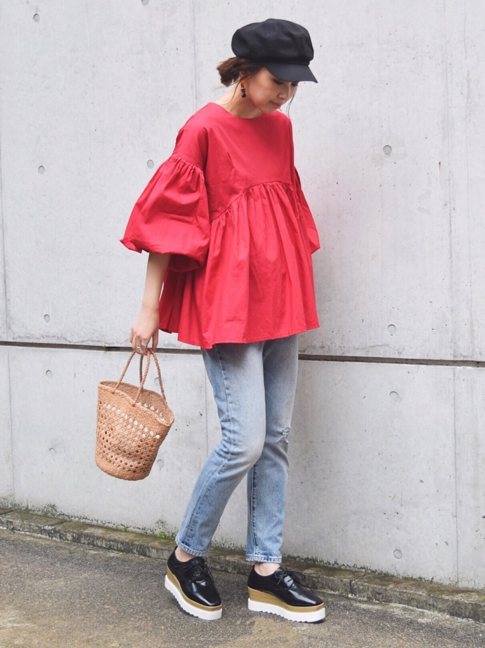 ベージュ系のバッグ、ブルー系のデニムパンツ、レッド系のシャツ/ブラウスを着用したレディースの春コーディネートの1枚目の写真