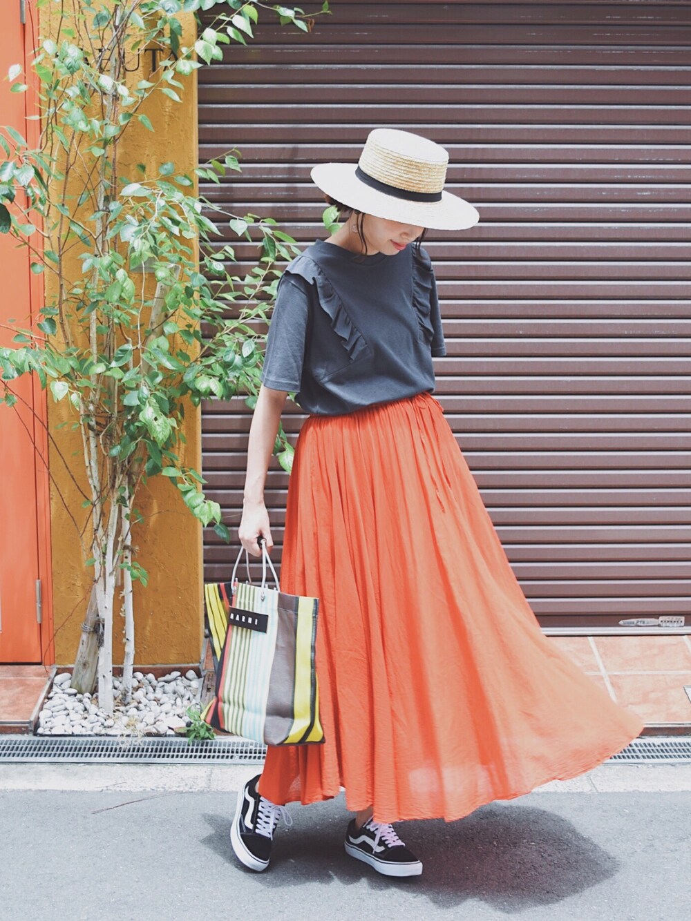 ブラック系のスニーカー、その他のトートバッグ、グレー系のTシャツ/カットソーを着用したレディースの夏コーディネートの1枚目の写真