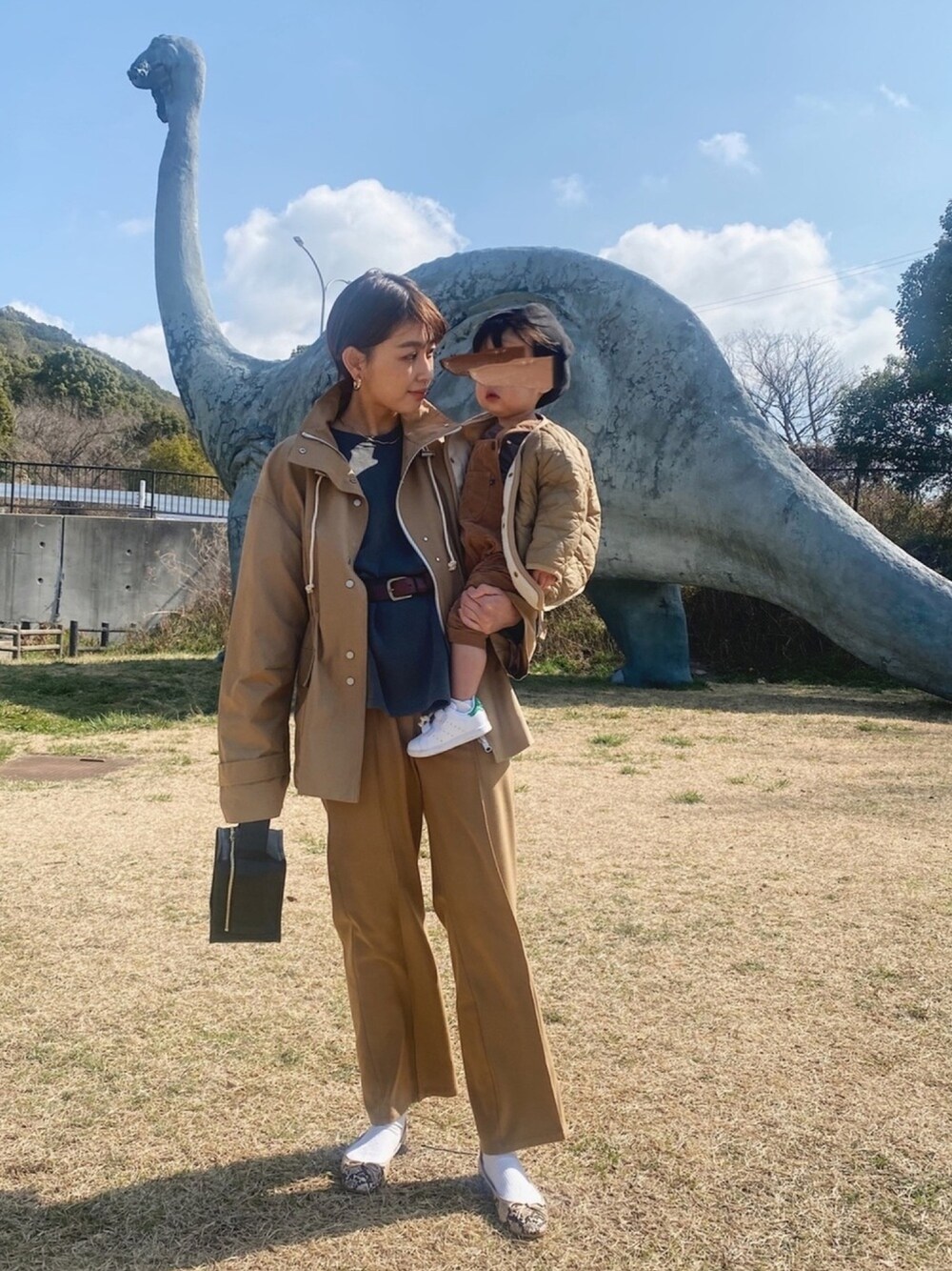 ベージュ系のナイロンジャケット、イエロー系のその他パンツ、ブラック系のハンドバッグを着用したレディースの春コーディネートの1枚目の写真