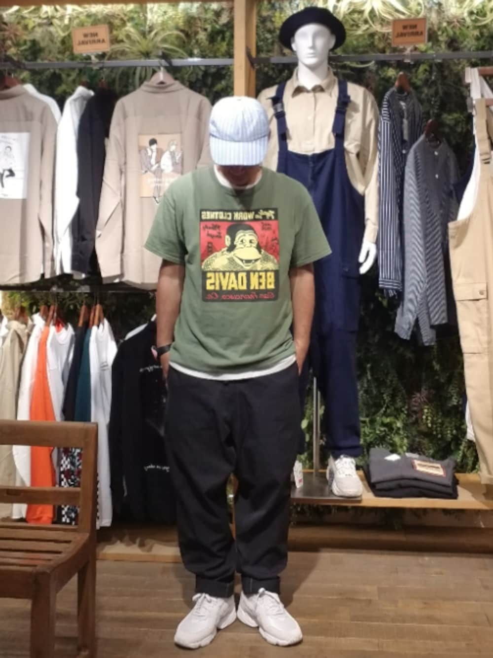 ブラック系のチノパンツ、グリーン系のTシャツ/カットソー、ホワイト系のスニーカーを着用したメンズの秋コーディネートの1枚目の写真