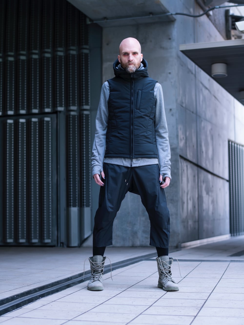 ブラック系のダウンベスト、グレー系のパーカー、ブラック系のその他パンツを着用したメンズの冬コーディネートの1枚目の写真