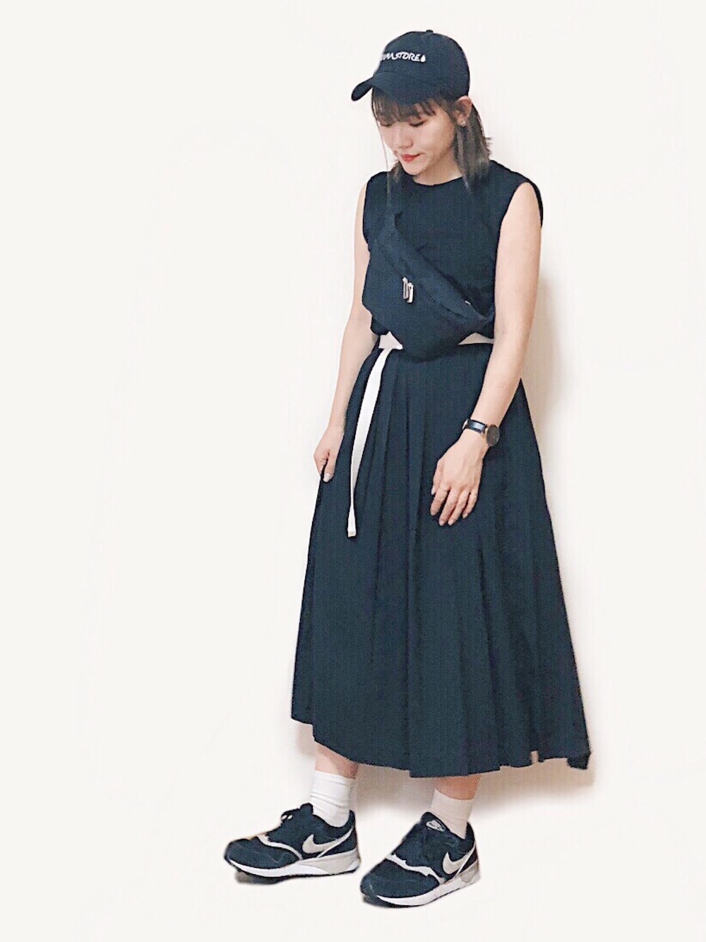 ブラック系のタンクトップ、ブラック系のスカート、ブラック系のボディバッグ/ウエストポーチを着用したレディースの夏コーディネートの1枚目の写真