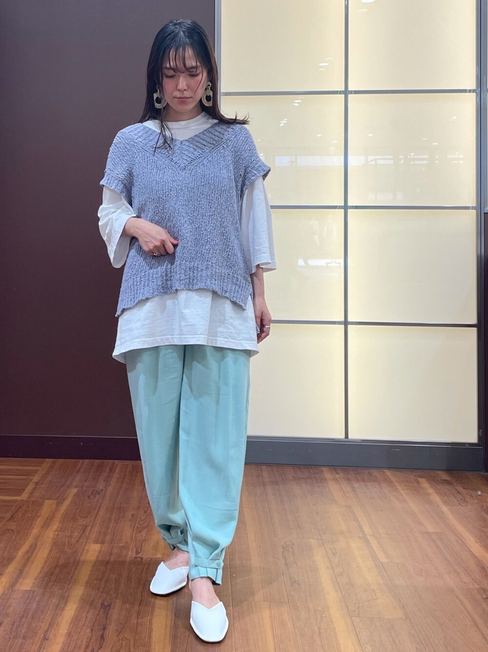 グレー系のベスト、ホワイト系のTシャツ/カットソー、グリーン系のその他パンツを着用したレディースの春コーディネートの1枚目の写真