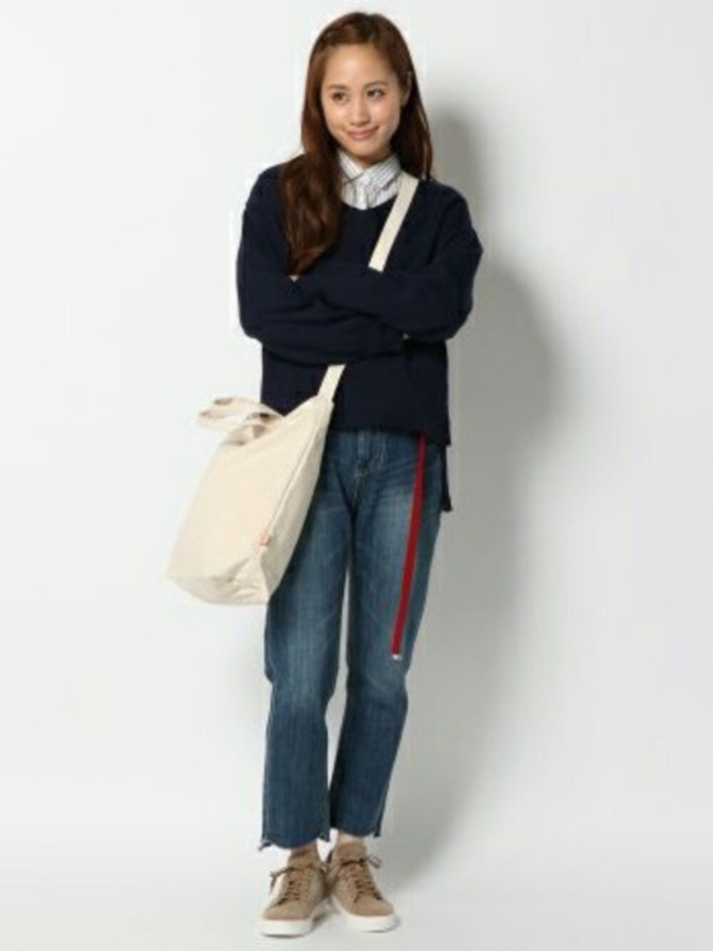 ブルー系のニット/セーター、ブルー系のデニムパンツ、ホワイト系のショルダーバッグを着用したメンズの冬コーディネートの1枚目の写真