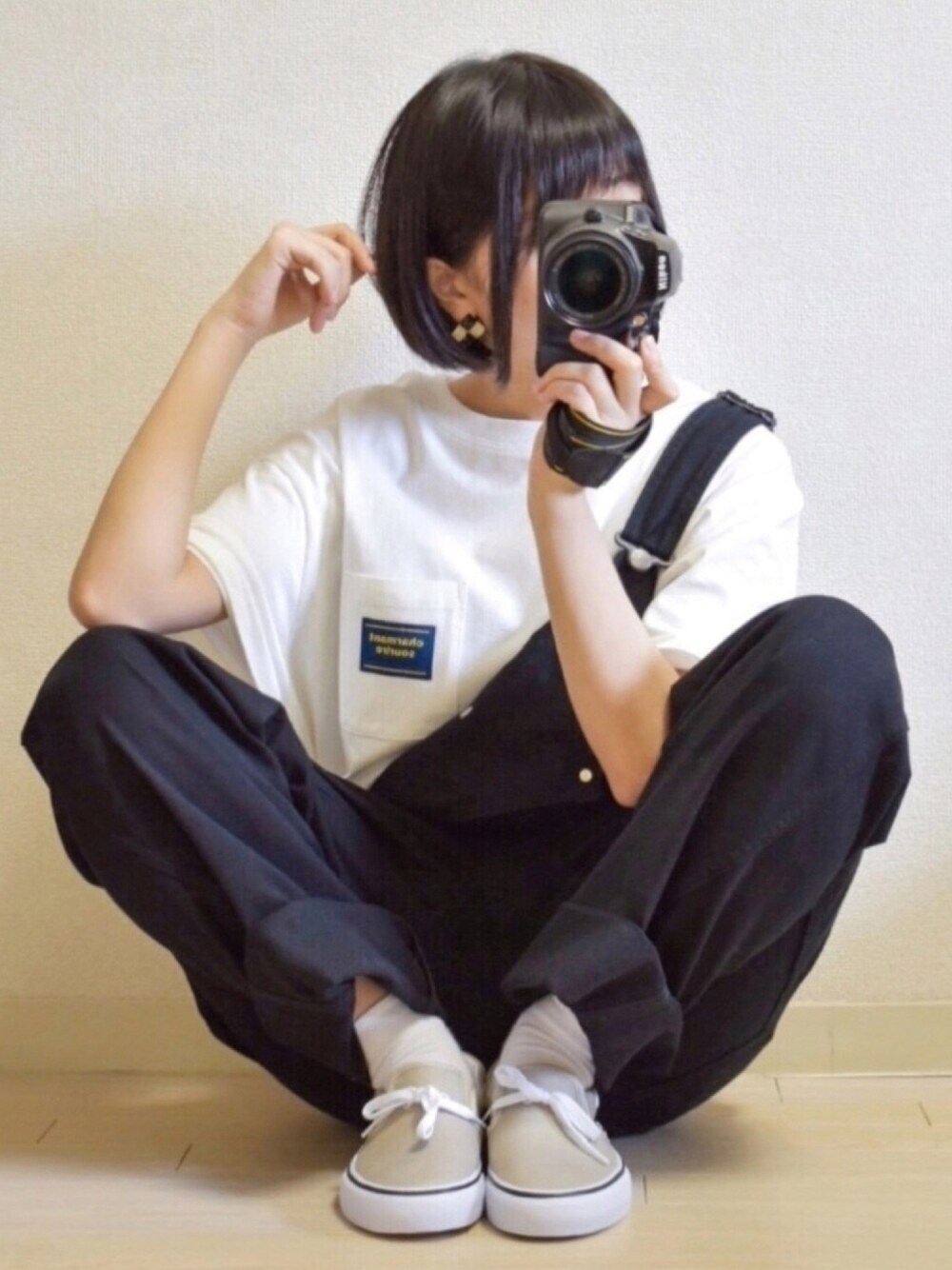 ブラック系のサロペット/オーバーオール、ベージュ系のスニーカー、ホワイト系のTシャツ/カットソーを着用したレディースの春コーディネートの1枚目の写真