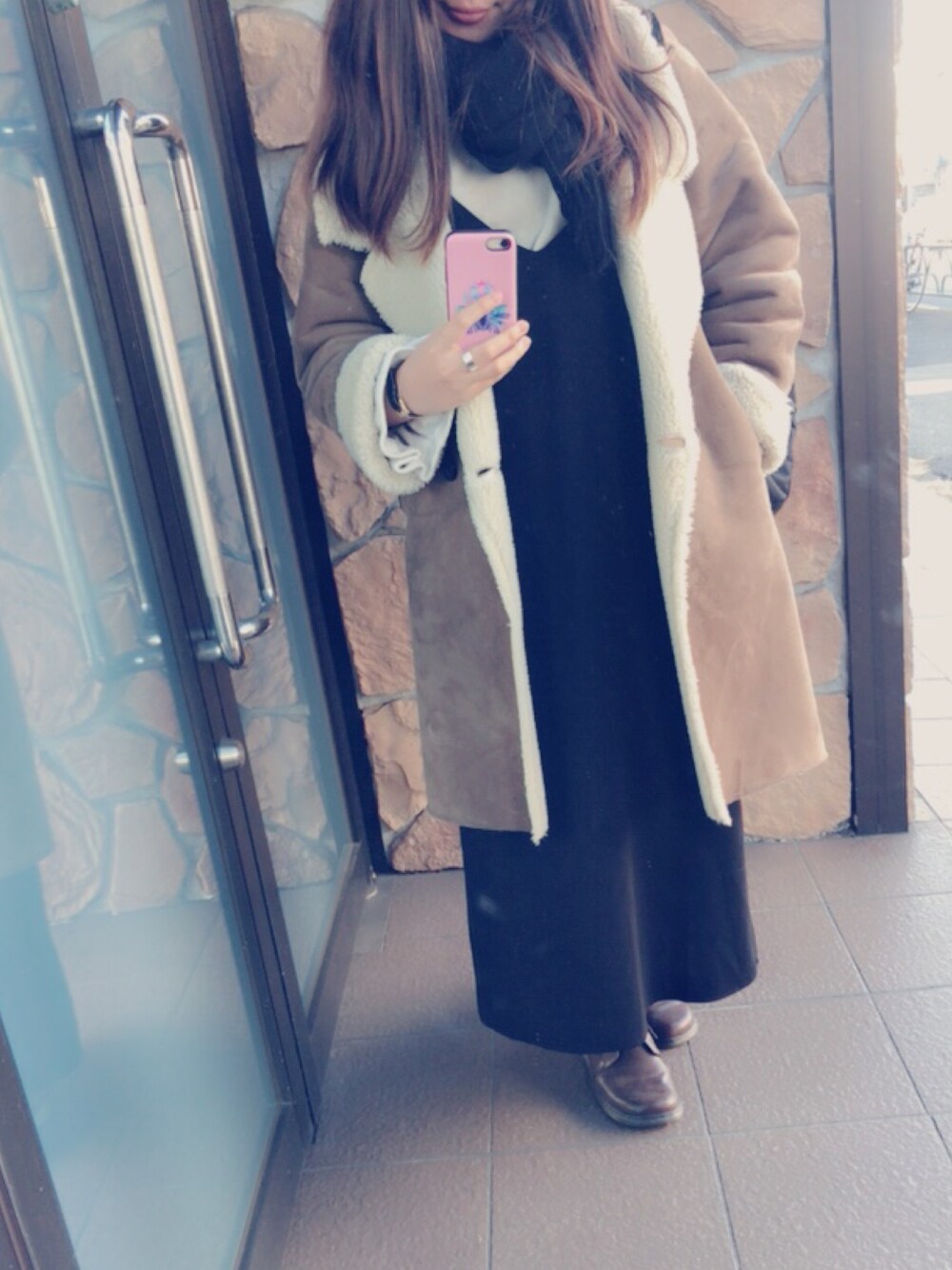 ブラウン系のブーツ、ブラック系のワンピース、ベージュ系のTシャツ/カットソーを着用したレディースの冬コーディネートの1枚目の写真