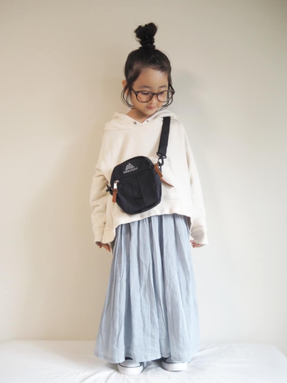 グリーン系のその他パンツ、ブラック系のショルダーバッグ、ホワイト系のパーカーを着用したキッズの春コーディネートの1枚目の写真