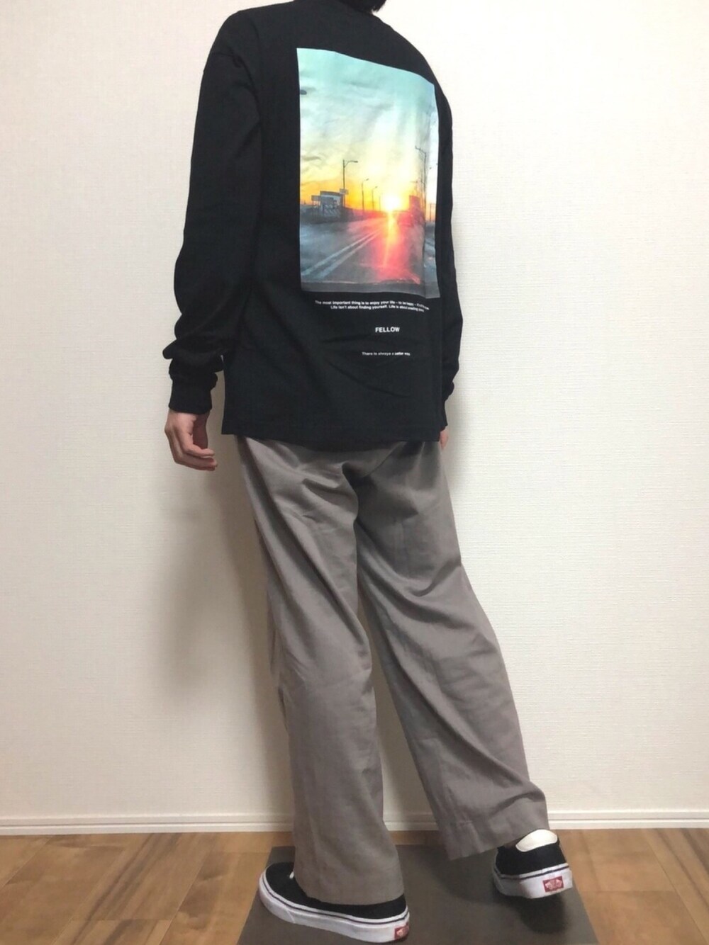 ブラック系のTシャツ/カットソー、グレー系のスラックス、ブラック系のスニーカーを着用したメンズの春コーディネートの1枚目の写真