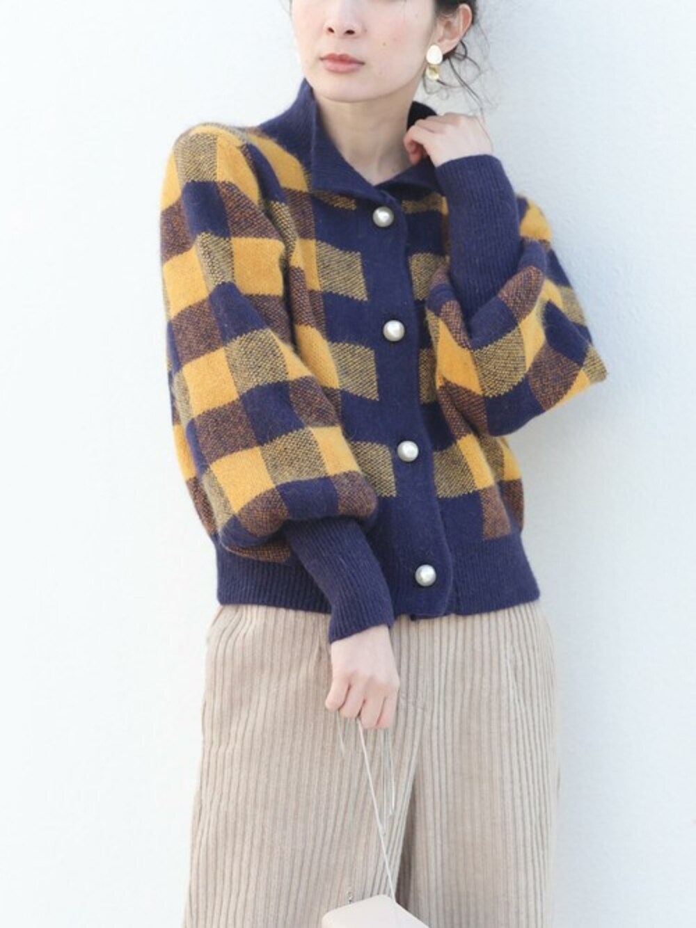 イエロー系のカーディガン/ボレロを着用したレディースの冬コーディネートの1枚目の写真