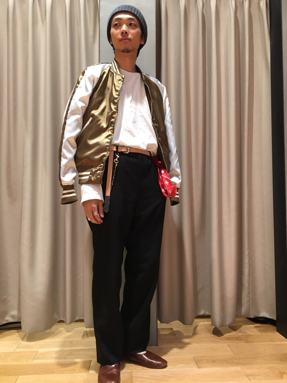 ブラウン系のブルゾン、ホワイト系のTシャツ/カットソー、ブラック系のスラックスを着用したメンズの春コーディネートの1枚目の写真