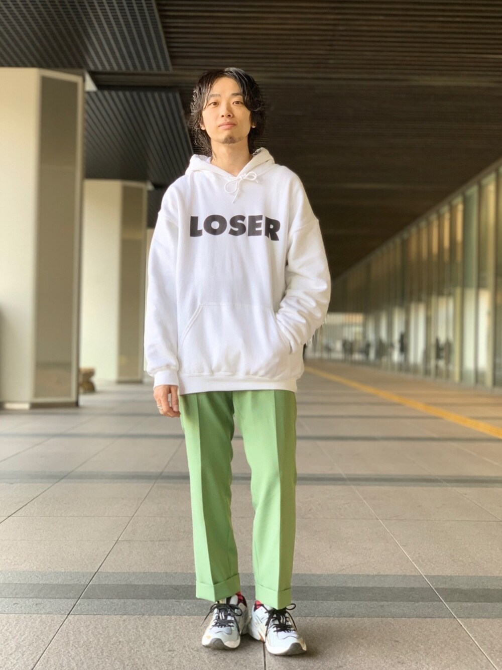 ホワイト系のパーカー、グリーン系のチノパンツ、グレー系のスニーカーを着用したメンズの冬コーディネートの1枚目の写真