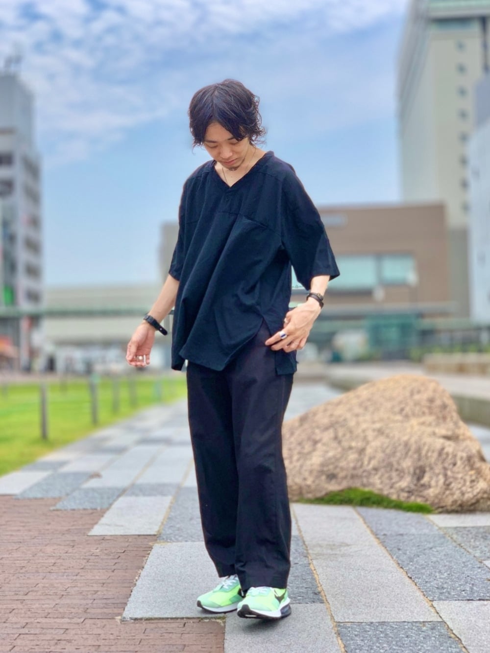 ブラック系のTシャツ/カットソー、ブラック系のスラックス、グリーン系のスニーカーを着用したメンズの夏コーディネートの1枚目の写真