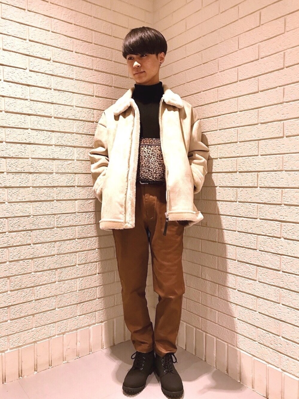 ブラック系のニット/セーター、ブラック系のブーツ、イエロー系のブルゾンを着用したメンズの秋コーディネートの1枚目の写真