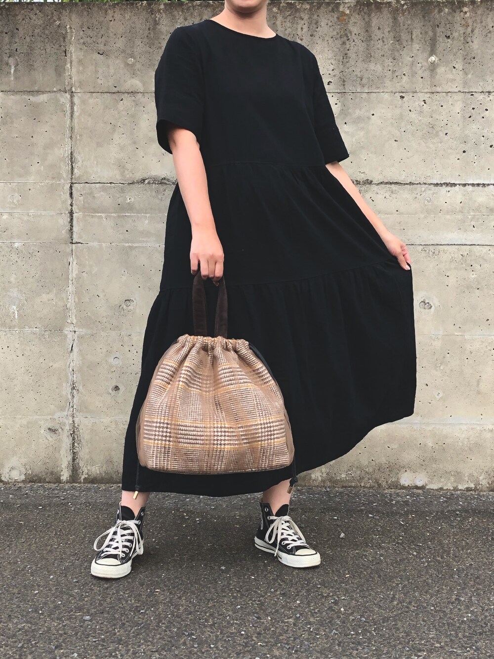 ブラック系のワンピース、ベージュ系のショルダーバッグ、ブラック系のスニーカーを着用したレディースの秋コーディネートの1枚目の写真