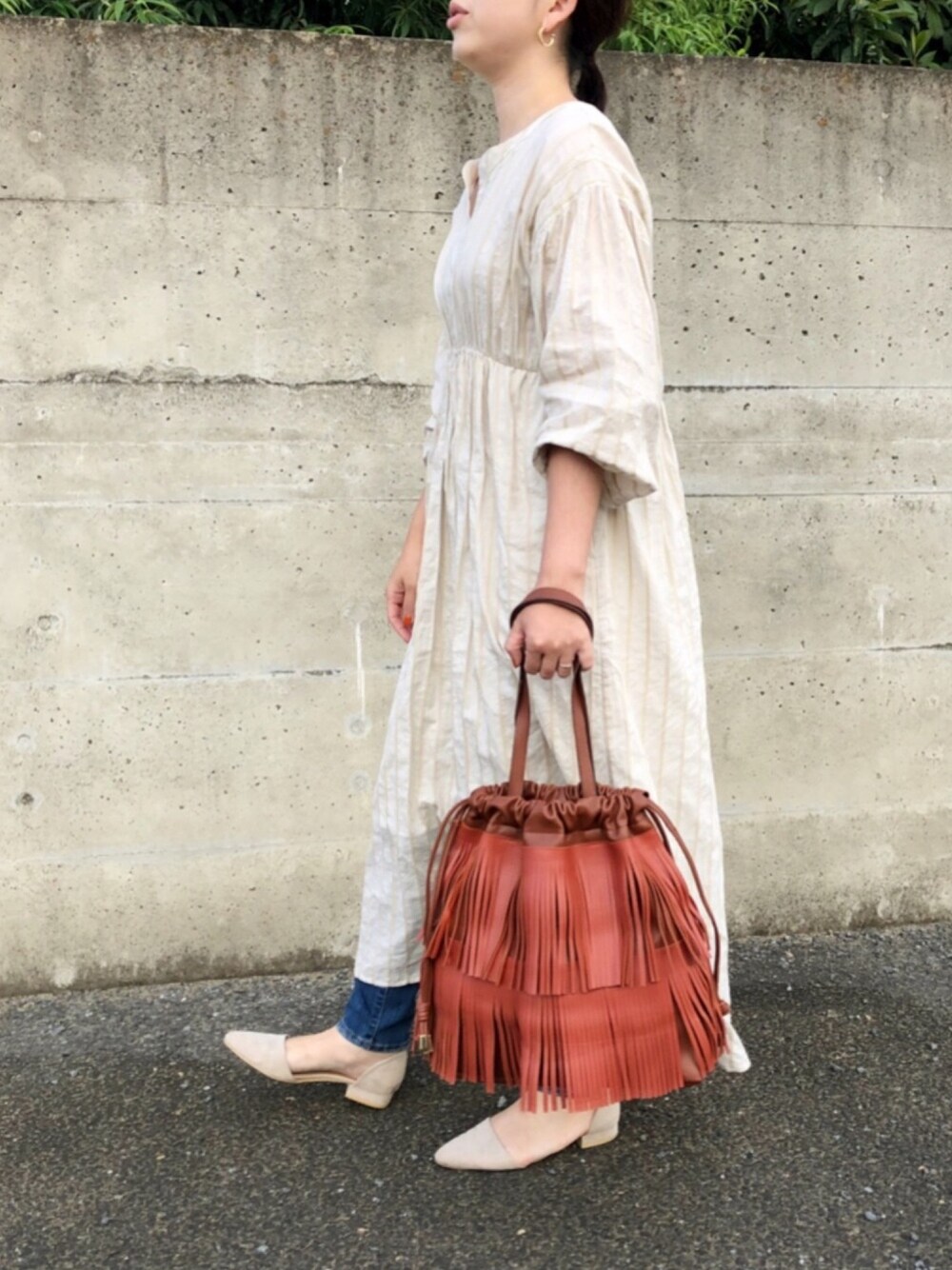 ホワイト系のワンピース、ブラウン系のトートバッグ、ベージュ系のパンプスを着用したレディースの秋コーディネートの1枚目の写真