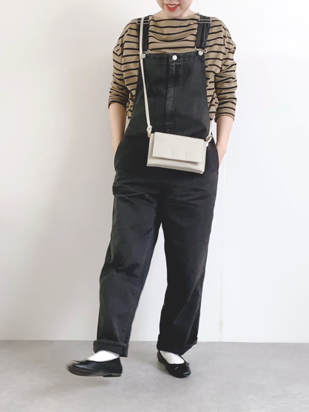 グレー系のショルダーバッグ、グレー系のサロペット/オーバーオール、ブラック系のバレエシューズを着用したレディースの春コーディネートの1枚目の写真