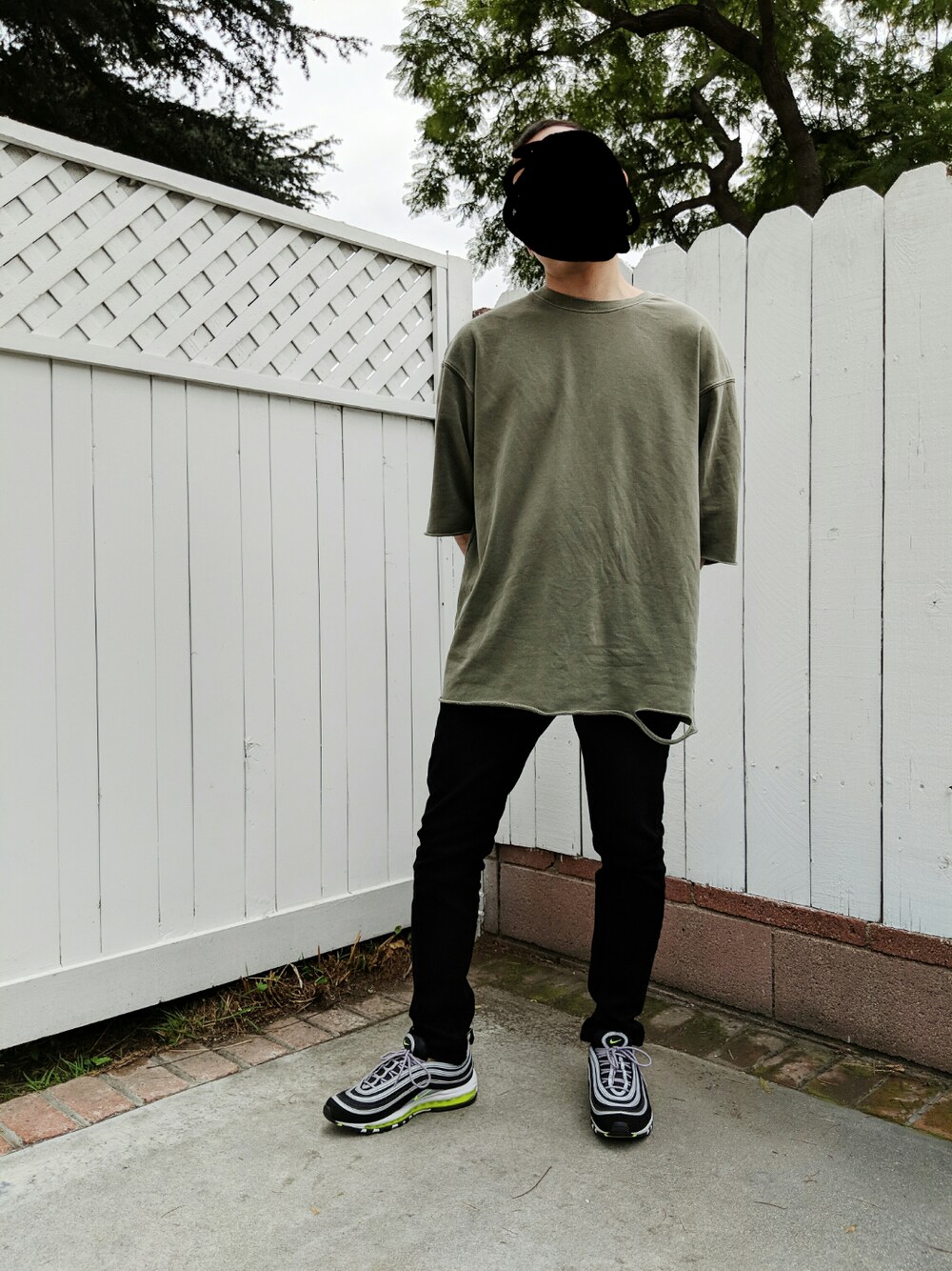 グリーン系のTシャツ/カットソー、ブラック系のデニムパンツ、ブラック系のスニーカーを着用したメンズの春コーディネートの1枚目の写真