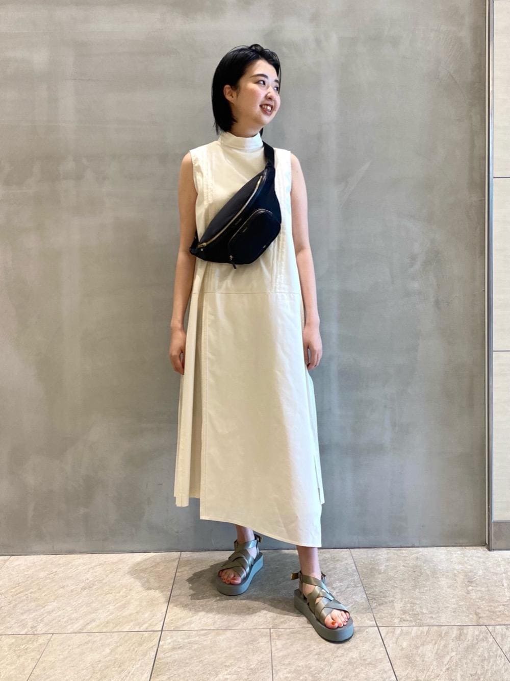 グレー系のサンダル、ホワイト系のワンピースを着用したレディースの春コーディネートの1枚目の写真