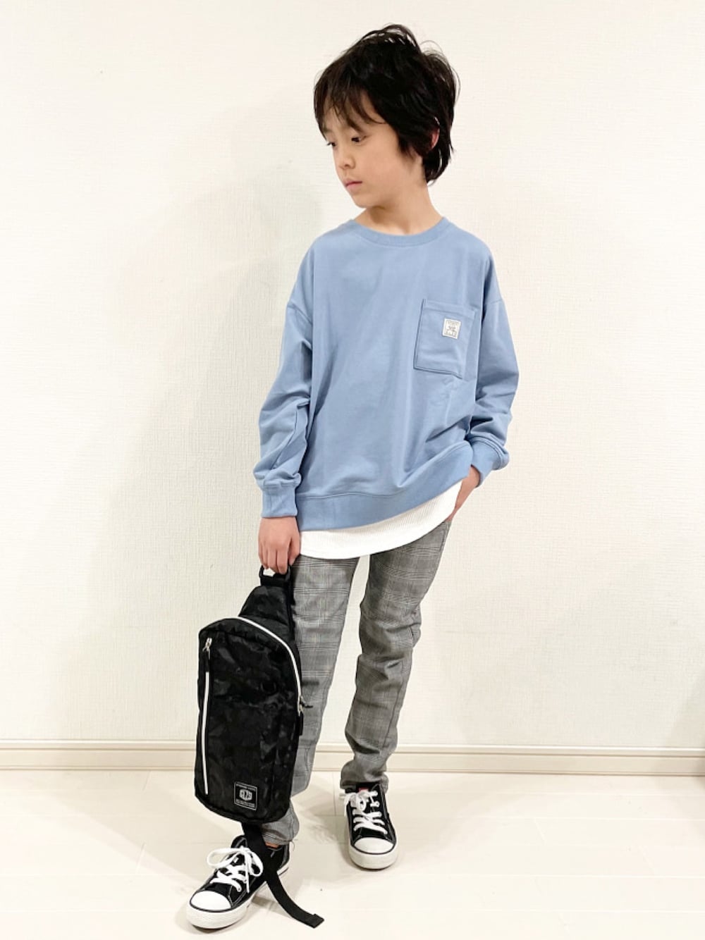 ブルー系のスウェット、ブルー系のチノパンツ、ブラック系のボディバッグ/ウエストポーチを着用したキッズの春コーディネートの1枚目の写真