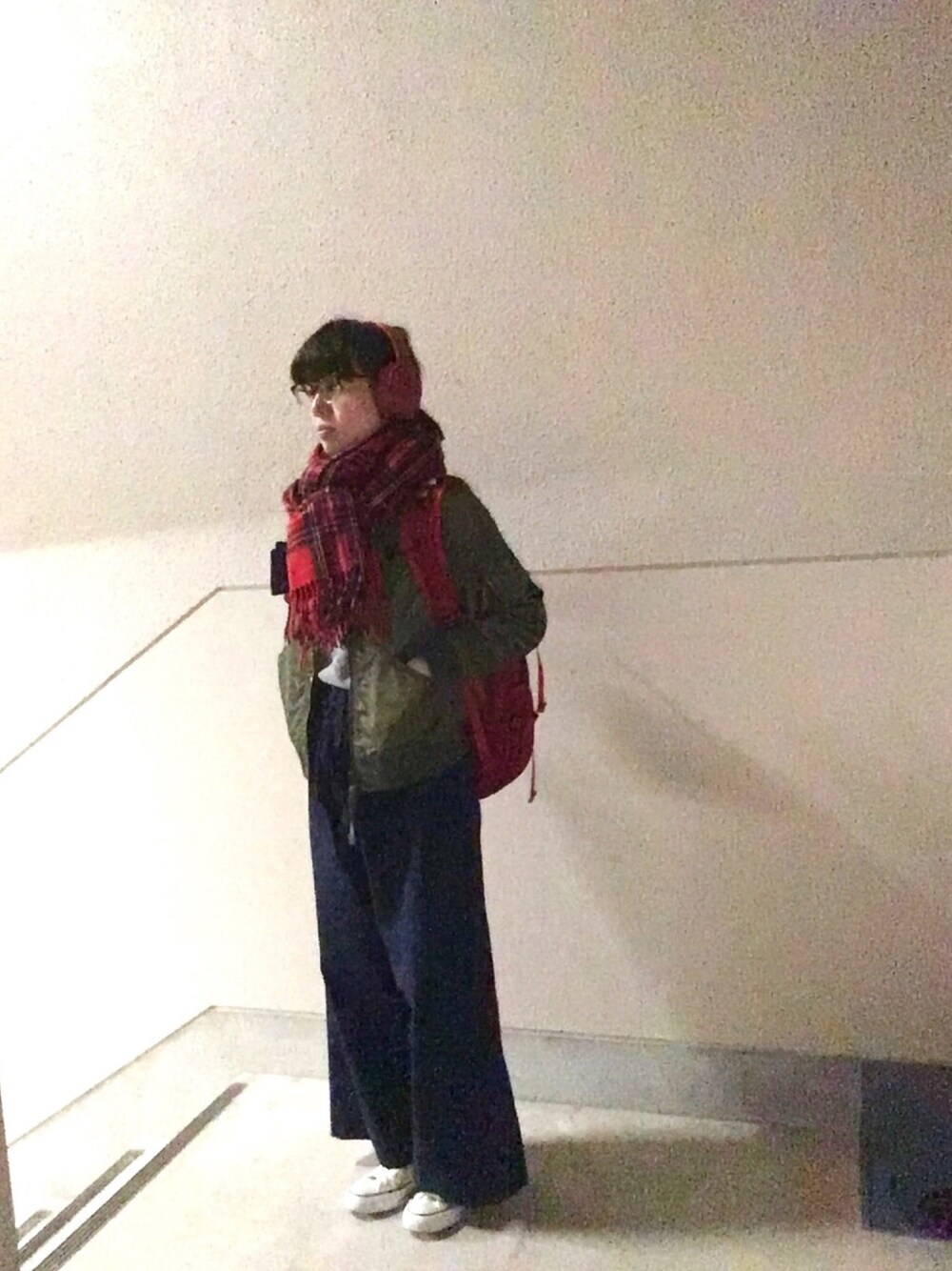 レッド系のバックパック/リュック、グリーン系のブルゾン、グレー系のニット/セーターを着用したレディースの冬コーディネートの1枚目の写真