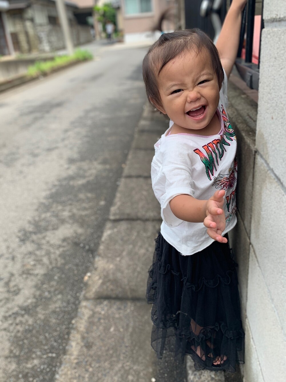 ホワイト系のTシャツ/カットソー、ブラック系のスカート、ブラック系のサンダルを着用したキッズの春コーディネートの1枚目の写真