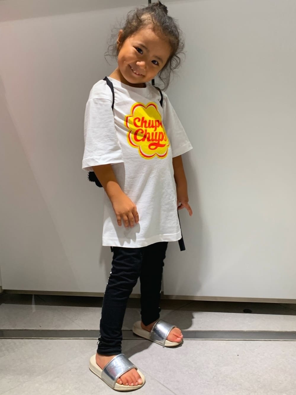 ホワイト系のTシャツ/カットソー、ブラック系のその他パンツ、シルバー系のサンダルを着用したキッズの春コーディネートの1枚目の写真