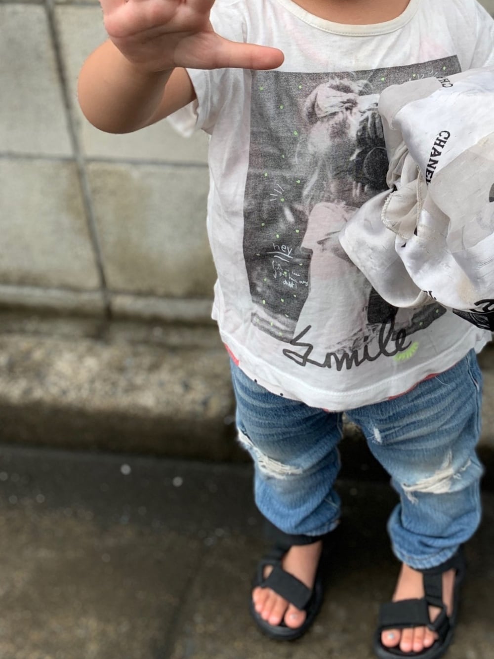 ホワイト系のTシャツ/カットソー、ブルー系のデニムパンツ、ブラック系のサンダルを着用したキッズの春コーディネートの1枚目の写真