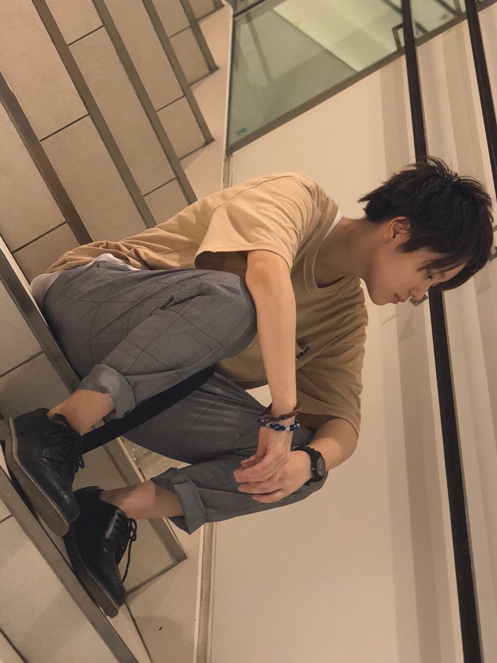 グレー系のスラックス、ホワイト系のタンクトップ、ベージュ系のTシャツ/カットソーを着用したメンズの夏コーディネートの1枚目の写真