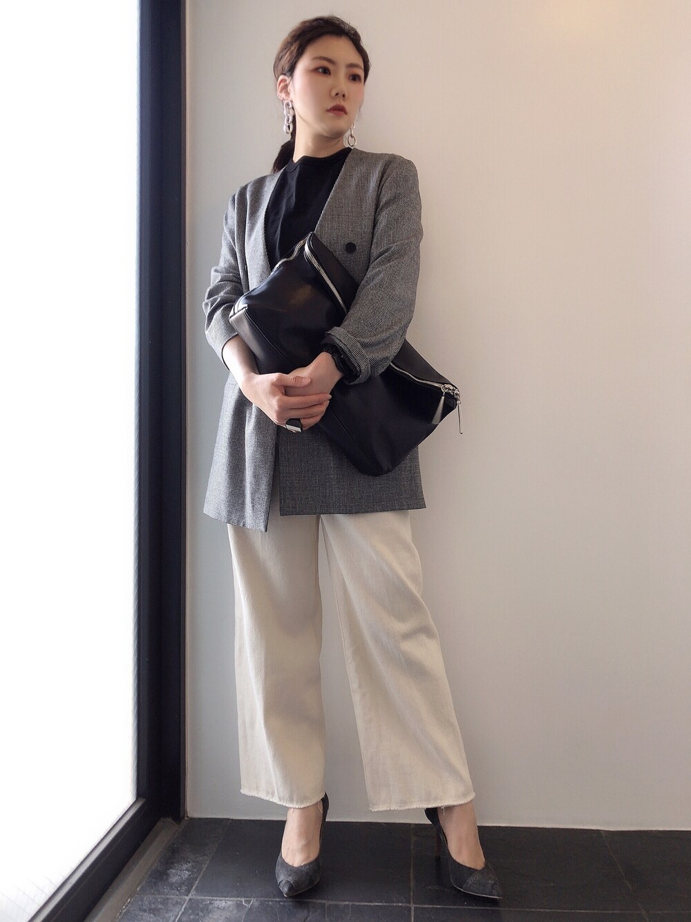 グレー系のノーカラージャケット、ブラック系のTシャツ/カットソー、ブラック系のクラッチバッグを着用したレディースの春コーディネートの1枚目の写真